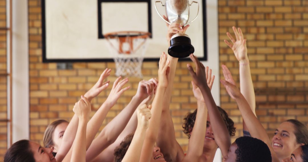 Diverse Basketball Team Celebrating Victory with Trophy in Gym - Free Images, Stock Photos and Pictures on Pikwizard.com