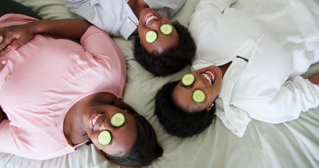 Friends Relaxing with Cucumber Slices on Eyes at Home Spa