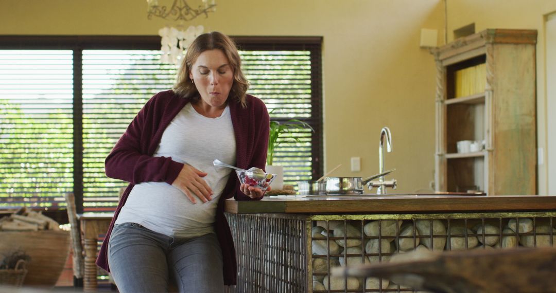 Pregnant Woman Enjoying Ice Cream in Modern Kitchen