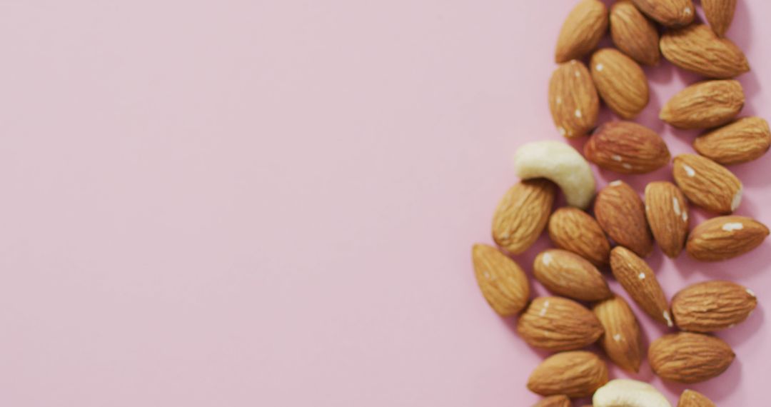 Assorted Almonds and Nuts on Vibrant Pink Background