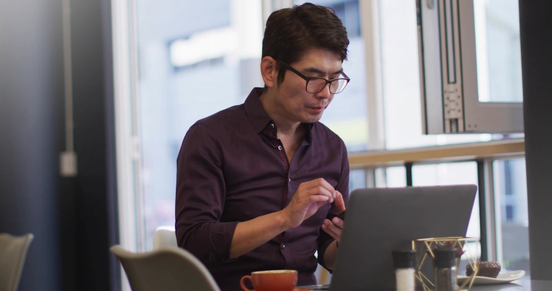 Businessman Efficiently Multitasking at Modern Cafe with Technology