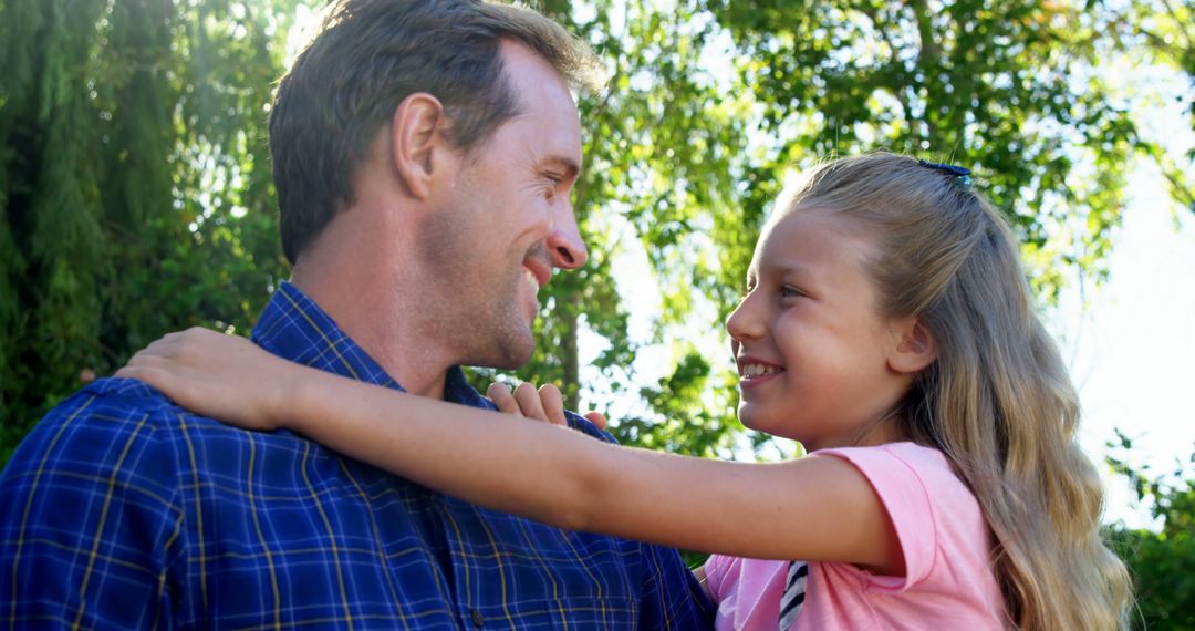 Smiling Father and Daughter Embracing Outdoors - Free Images, Stock Photos and Pictures on Pikwizard.com