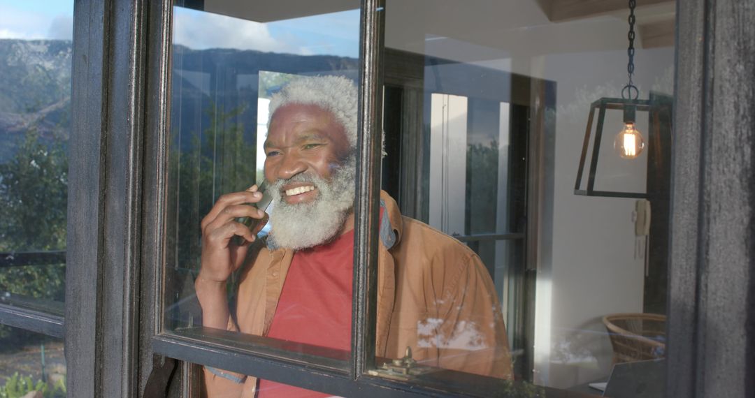 African American Elder Enjoying Phone Call by Window