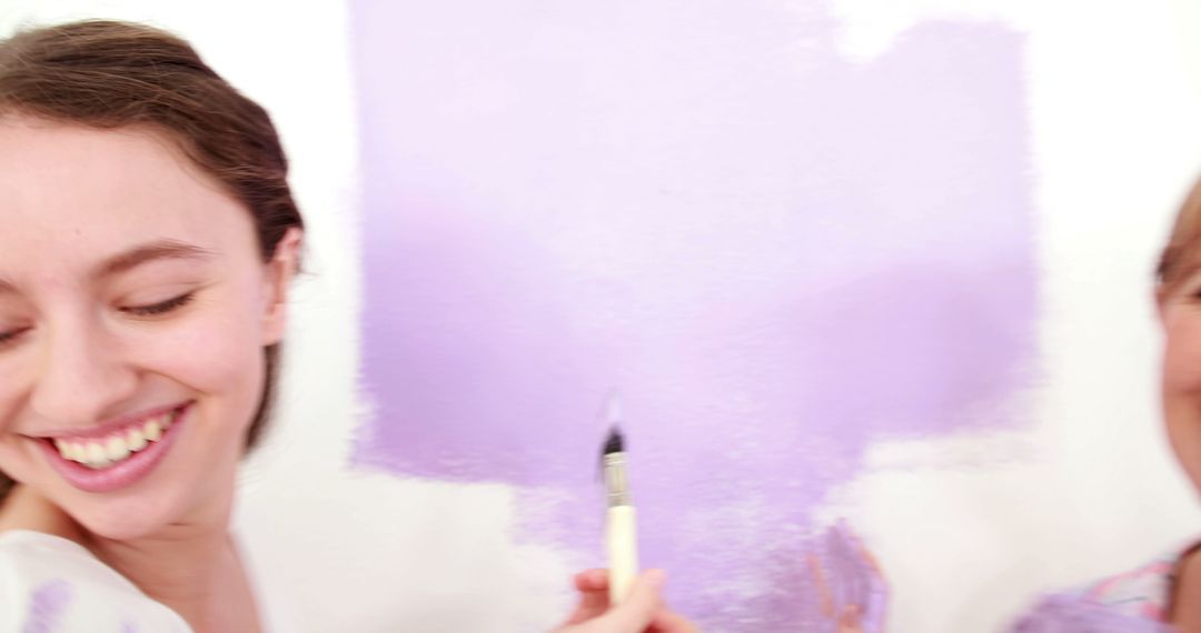 Two Women Smiling While Painting Wall Lavender - Free Images, Stock Photos and Pictures on Pikwizard.com