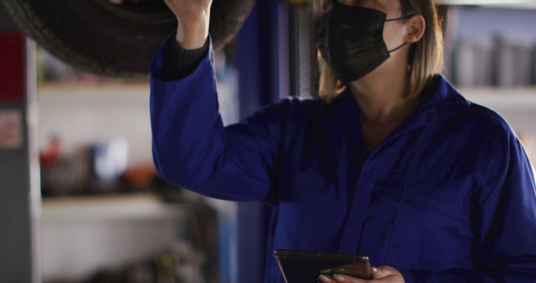 Female Auto Mechanic Inspecting Vehicle Tire in Workshop - Free Images, Stock Photos and Pictures on Pikwizard.com