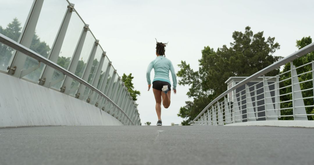 Active african american woman running on urban bridge