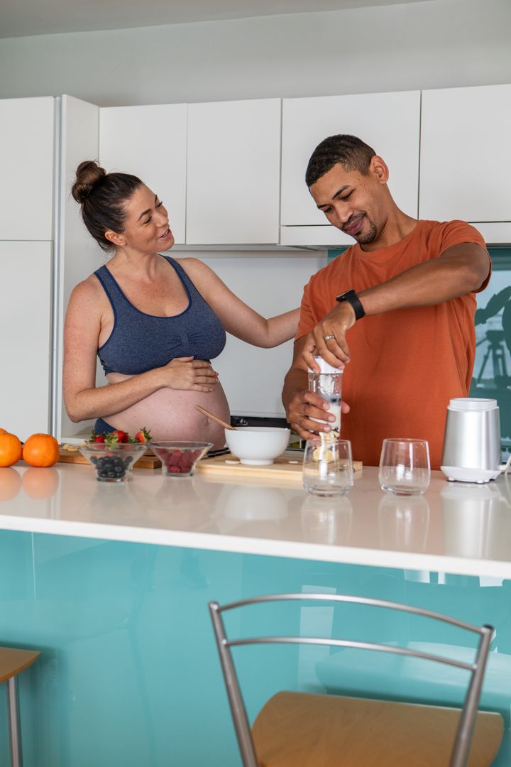 Expecting Couple Preparing Healthy Drink in Modern Kitchen