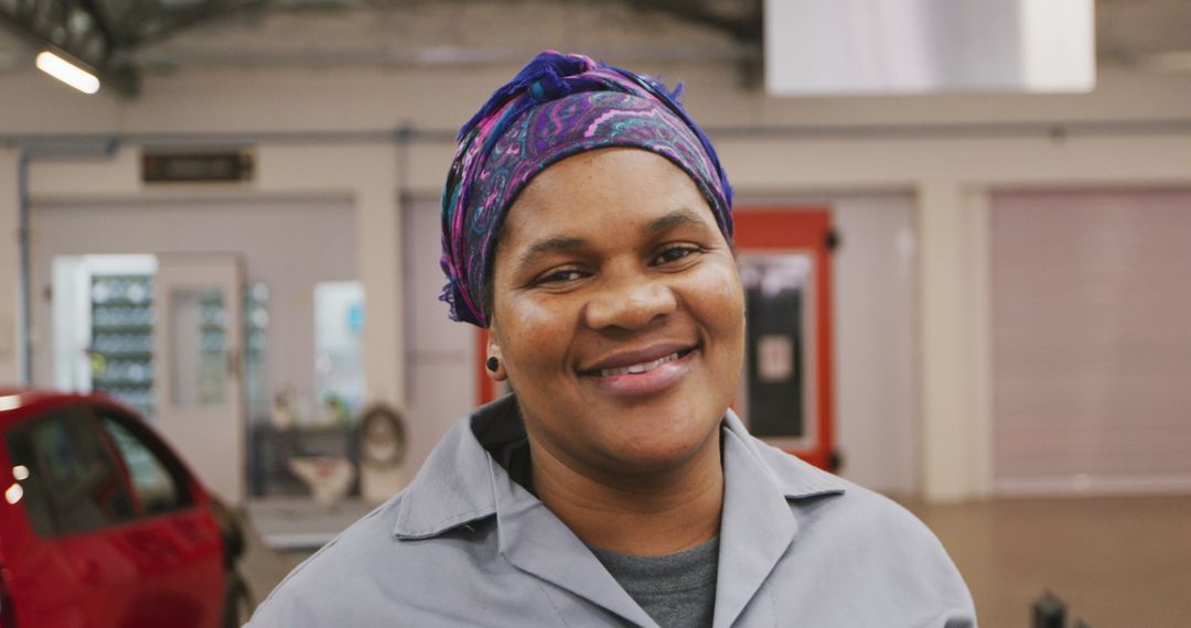 Smiling Mechanic in Workshop with Car and Tools