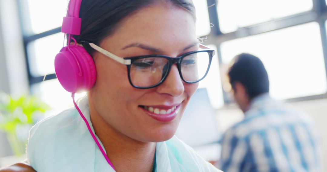 Woman with Headphones and Glasses Smiling at Work - Free Images, Stock Photos and Pictures on Pikwizard.com