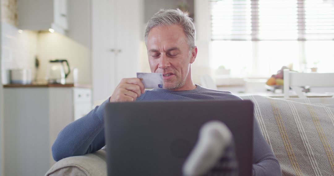 Middle-aged man making online purchase with credit card at home - Free Images, Stock Photos and Pictures on Pikwizard.com