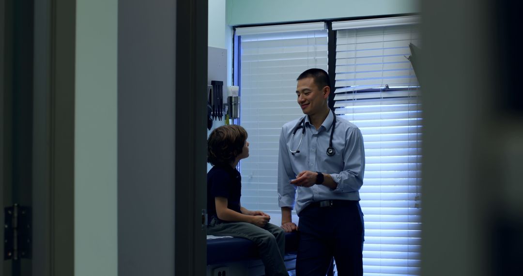 Male Doctor Interacting with Young Patient in Examination Room - Free Images, Stock Photos and Pictures on Pikwizard.com