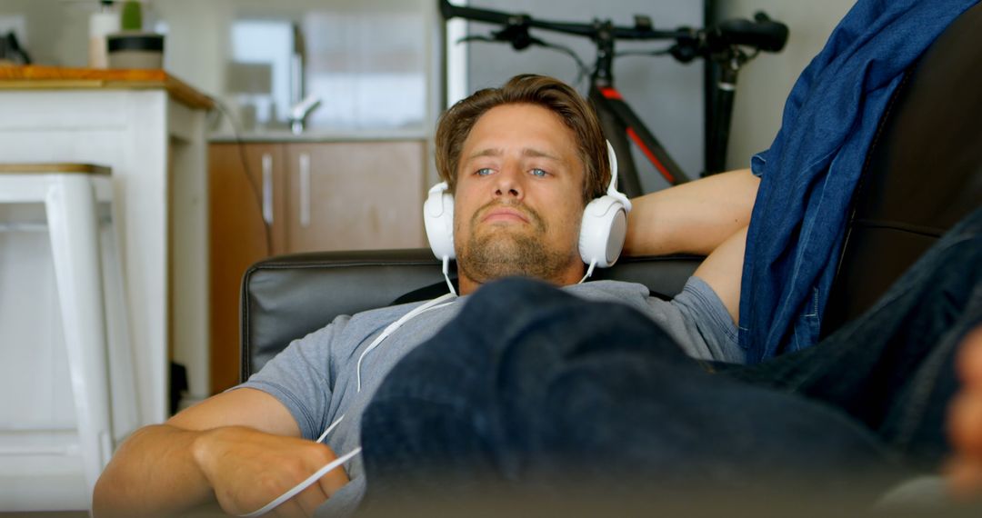 Young Man Relaxing on Couch with Headphones in Living Room - Free Images, Stock Photos and Pictures on Pikwizard.com