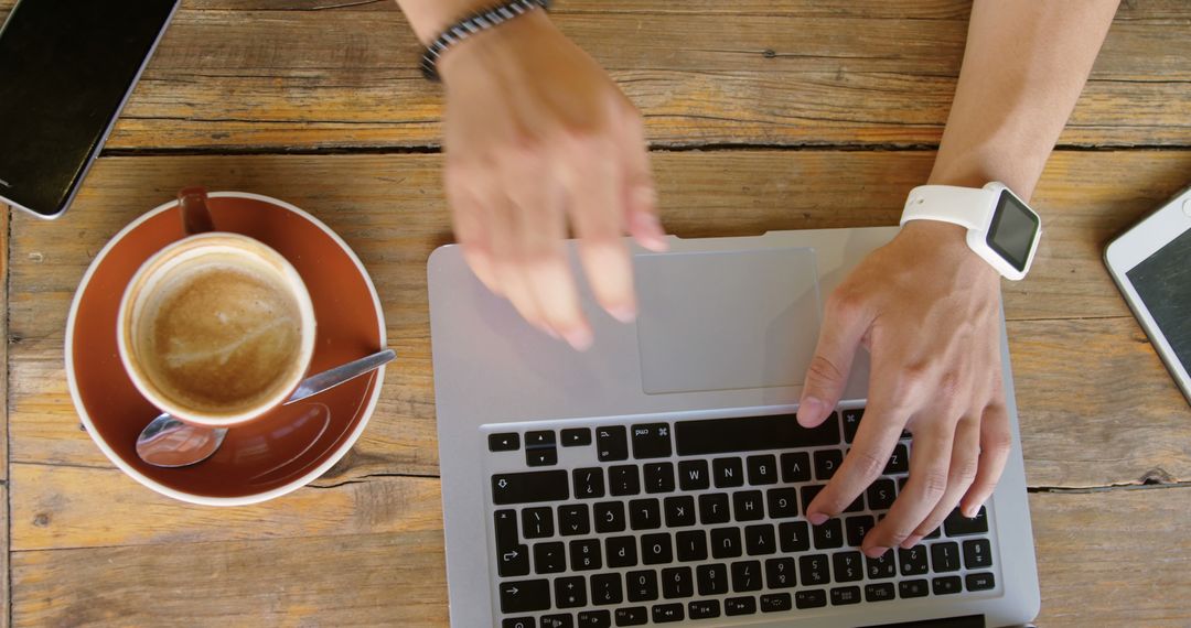 Top View of Person Using Laptop with Coffee on Wooden Table - Free Images, Stock Photos and Pictures on Pikwizard.com