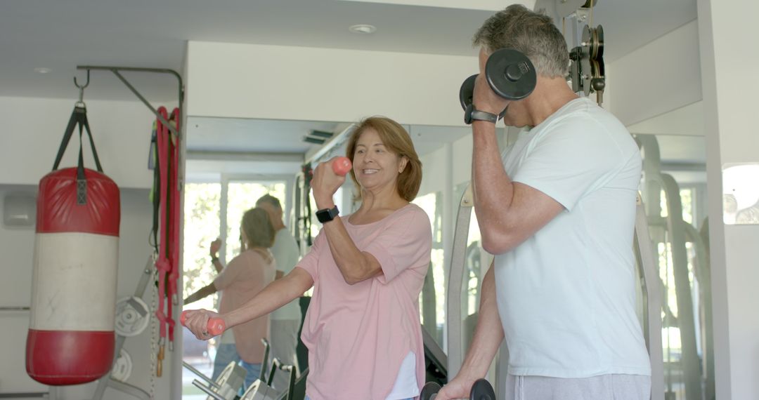 Senior Couple Exercising with Dumbbells in Home Gym