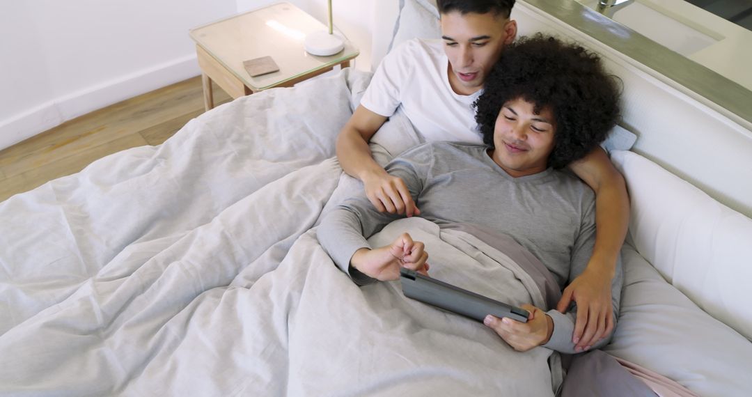 Cozy Couple Relaxing in Bed Using Tablet at Home