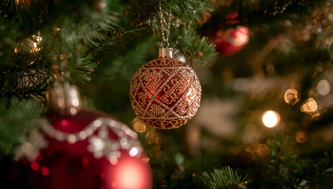 Elegant Red and Gold Christmas Bauble on Tree Branch with Warm Bokeh
