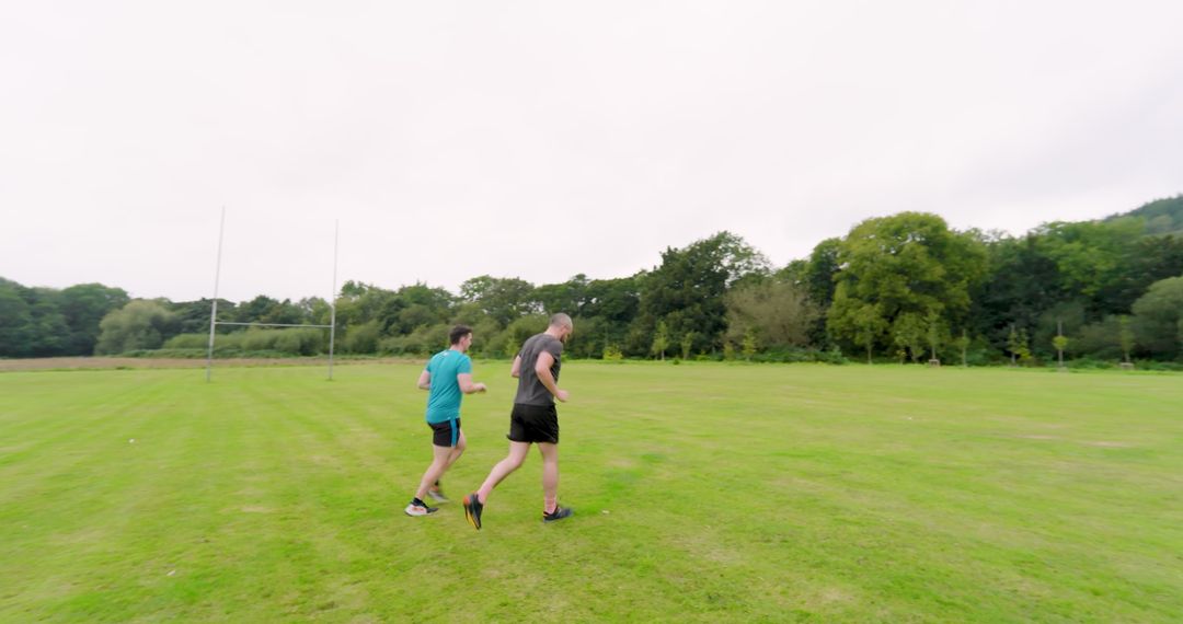 Men Jogging on Lush Green Field for Fitness Enjoyment