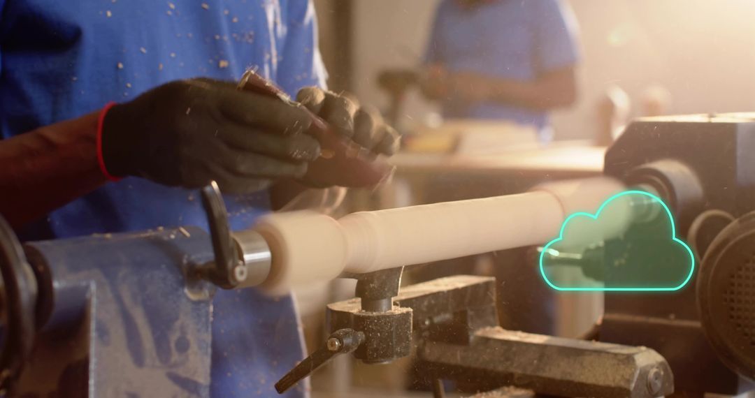 Skilled woodturner shaping wooden spindle on lathe in sunlit workshop with wood shavings
