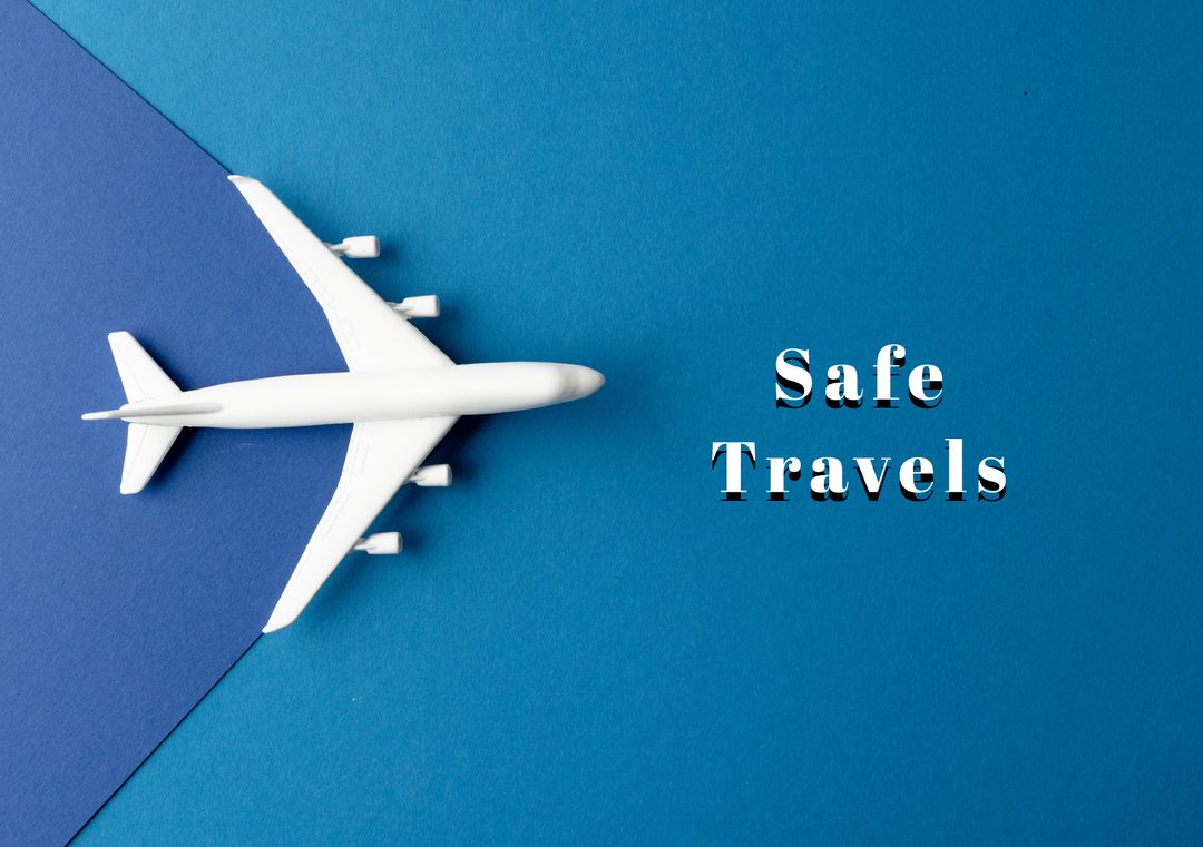 Toy Airplane and Safe Travels Text on Blue Background