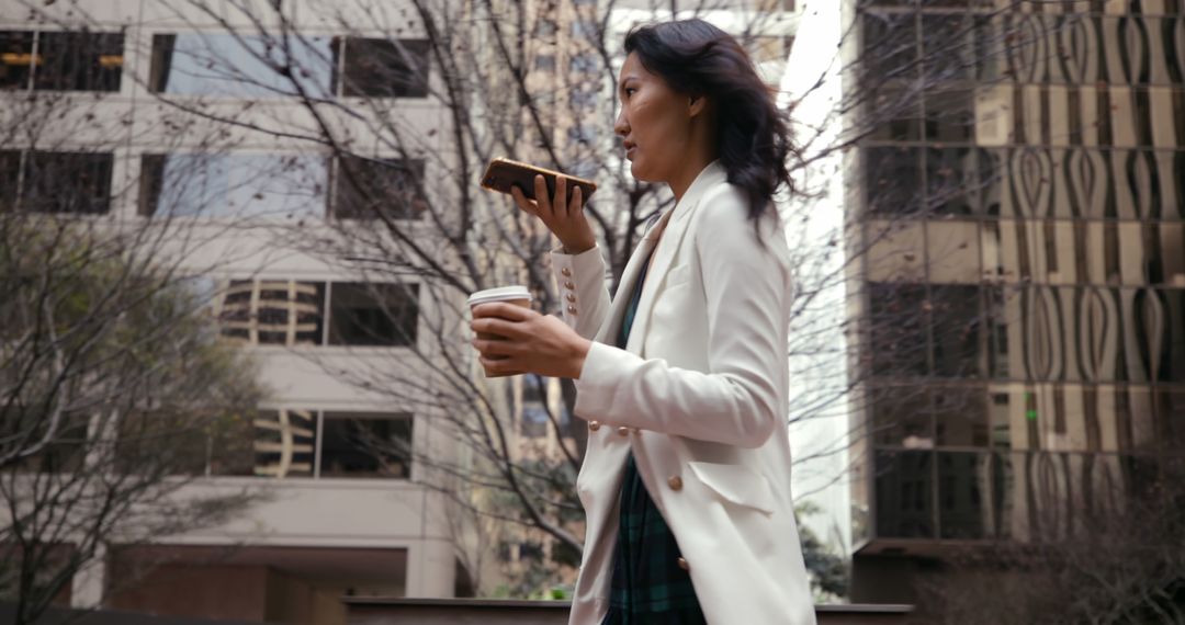 Businesswoman Talking on Phone While Holding Coffee in City - Free Images, Stock Photos and Pictures on Pikwizard.com