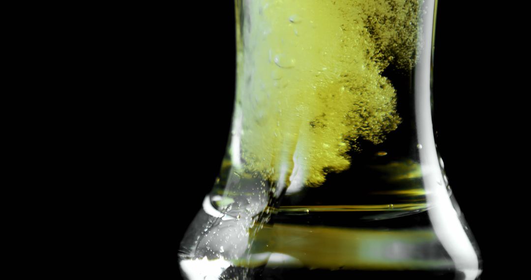 Refreshing Beer Pour with Bubbles and Foam Against Black Background
