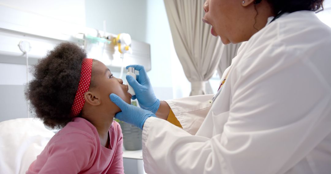 Pediatric Doctor Examining Child with Reflective Headband in Hospital - Free Images, Stock Photos and Pictures on Pikwizard.com