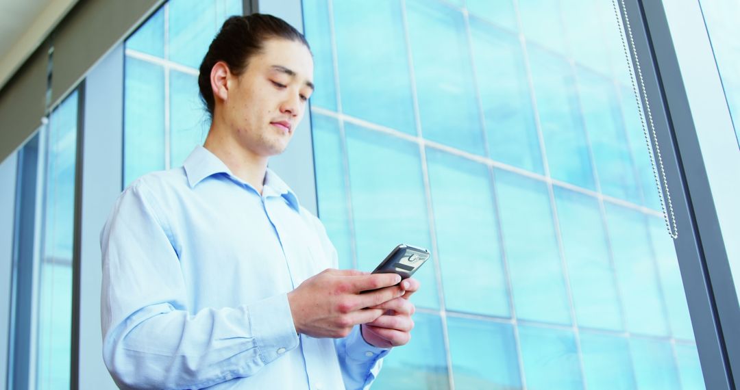 Young Professional Man Texting on Smartphone in Office - Free Images, Stock Photos and Pictures on Pikwizard.com