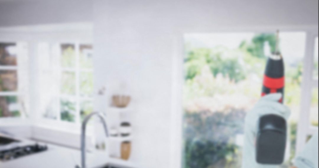 Hand Using Power Drill in Modern Bright Kitchen