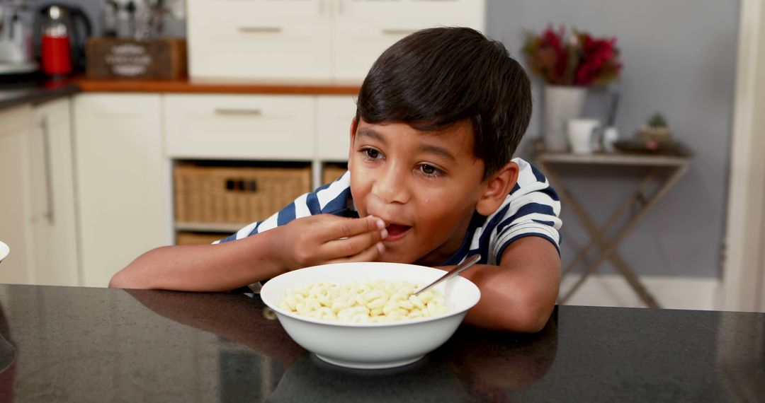 Young Boy Eating Cereal at Kitchen Counter - Free Images, Stock Photos and Pictures on Pikwizard.com