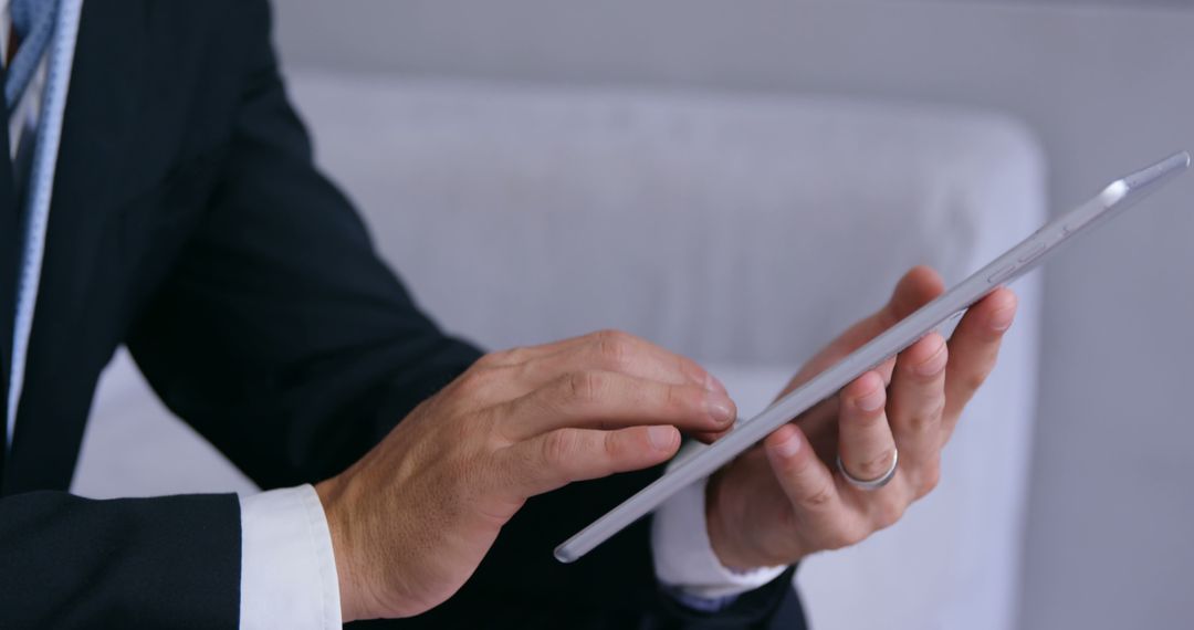 Businessman Using Digital Tablet in Formal Wear Indoor Setting