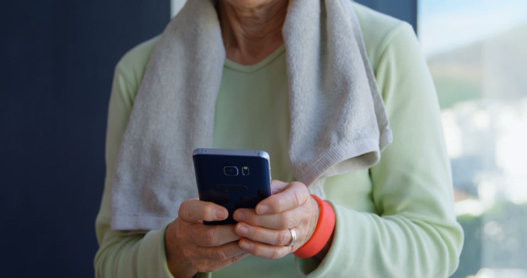 Senior woman using smartphone after exercise in gym - Free Images, Stock Photos and Pictures on Pikwizard.com