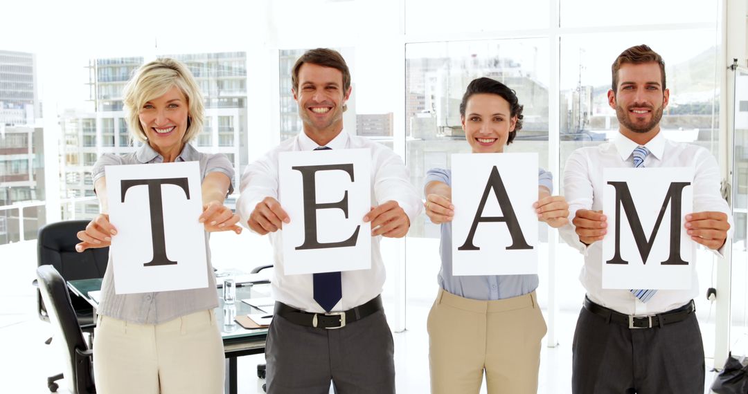 Smiling Business Team Holding Letters T-E-A-M in Office