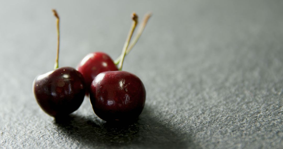 Close-Up of Three Fresh Cherries on Black Surface - Free Images, Stock Photos and Pictures on Pikwizard.com