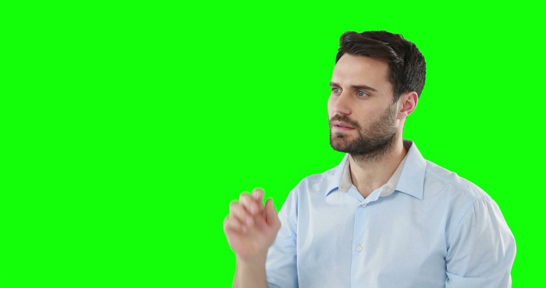 Man Staring Intently with Hand Raised Against Green Screen - Free Images, Stock Photos and Pictures on Pikwizard.com