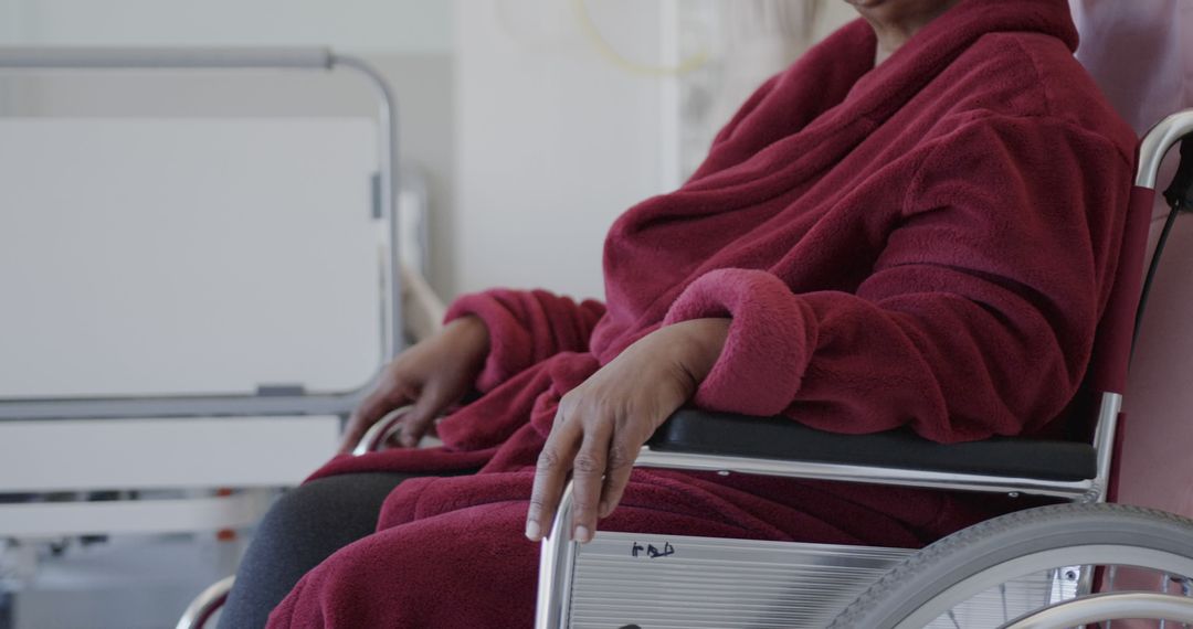 Elderly Woman in Red Robe Sitting in Wheelchair at Hospital - Free Images, Stock Photos and Pictures on Pikwizard.com