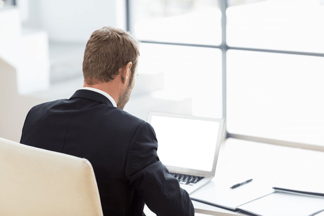 Businessman at Desk with Transparent Laptop Screen in Office