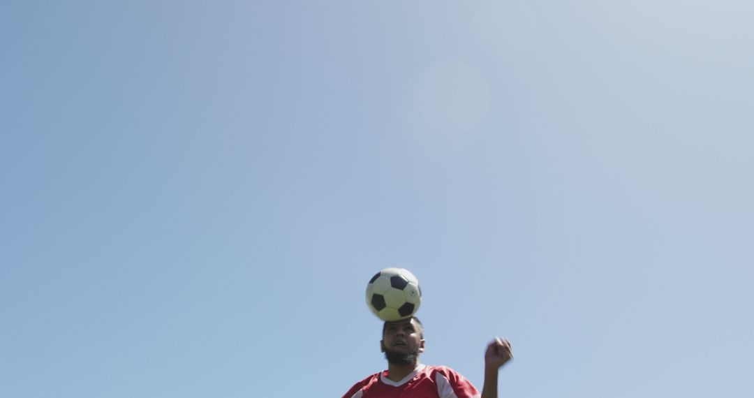 Soccer Player Heading Ball Against Clear Sky - Free Images, Stock Photos and Pictures on Pikwizard.com