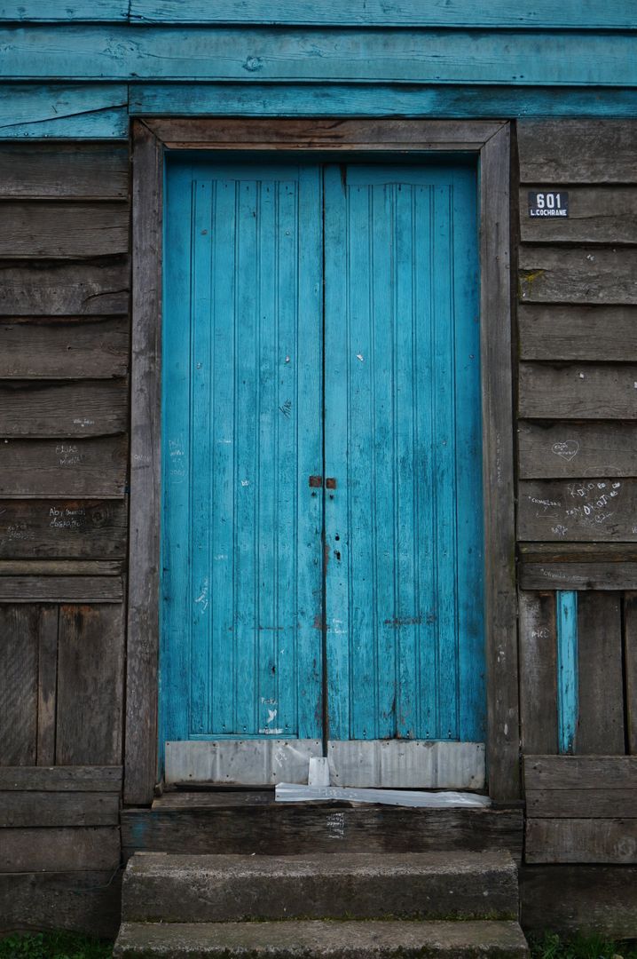Aged blue wooden door in weathered rustic facade - Free Images, Stock Photos and Pictures on Pikwizard.com