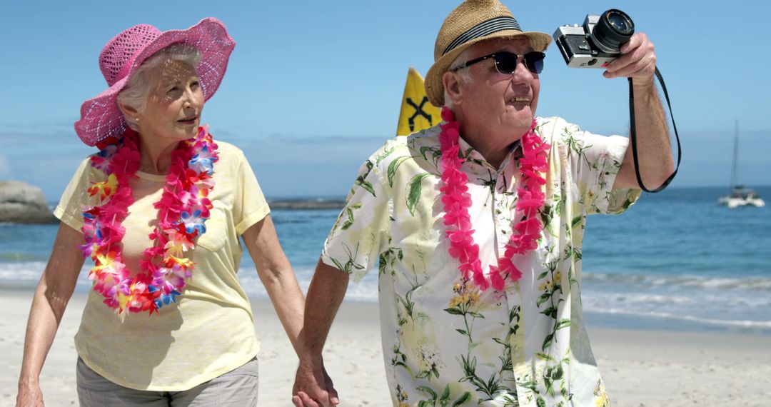 Happy Senior Couple with Hawaiian Garlands Strolling on Beach - Free Images, Stock Photos and Pictures on Pikwizard.com