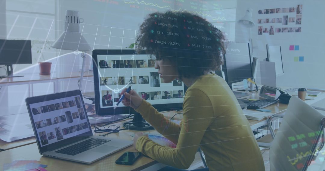 Creative Professional Analyzing Data on Dual Screens in Modern Office