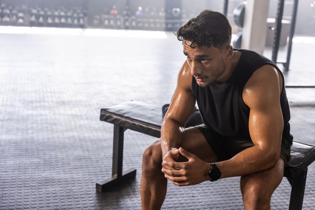 Young Athlete Taking Break Between Intense Workout Sessions in Gym