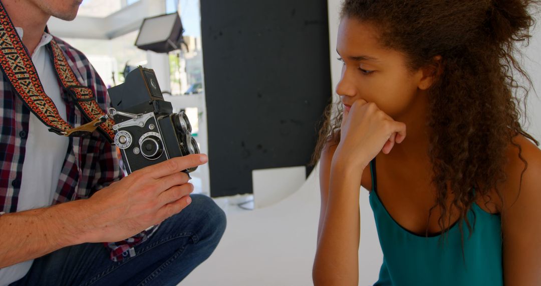 Photographer showing camera to thoughtful model in studio - Free Images, Stock Photos and Pictures on Pikwizard.com