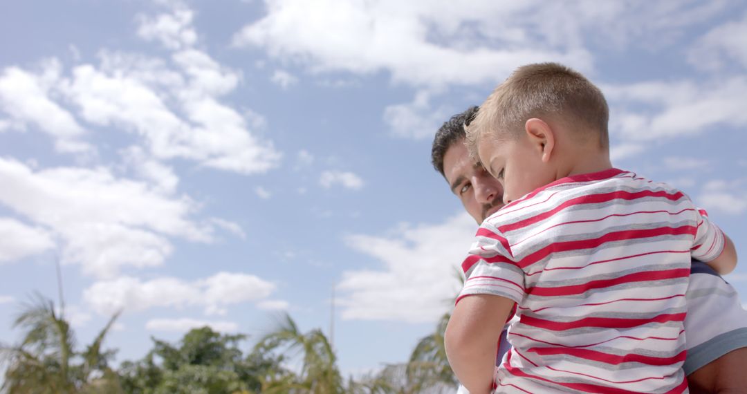 Father Holding Son Outdoors on a Sunny Day - Free Images, Stock Photos and Pictures on Pikwizard.com