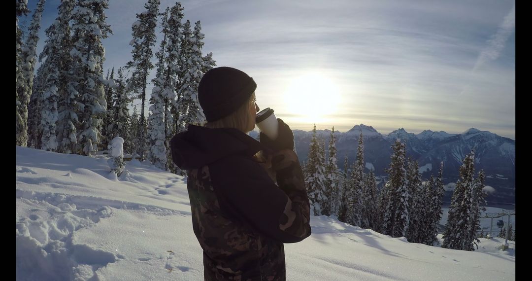 Winter Hiker Drinking Hot Beverage in Snowy Mountain Landscape at Sunrise - Free Images, Stock Photos and Pictures on Pikwizard.com