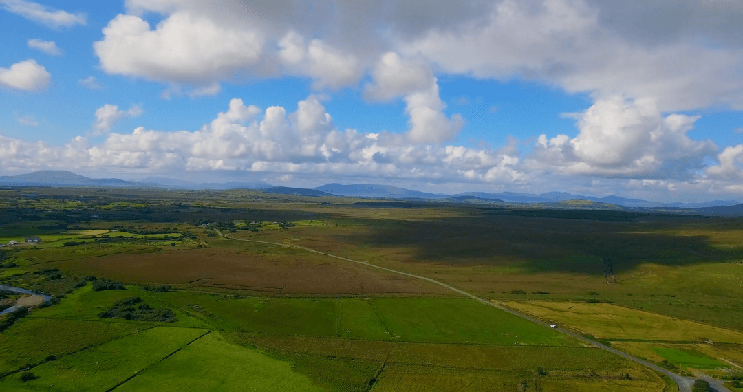 Transparent View of Expansive Green Fields and Cloudy Blue Horizon