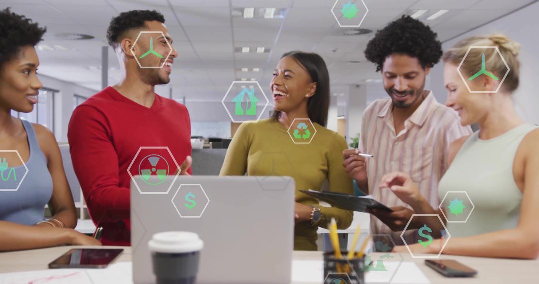 Diverse team collaborating around laptop in modern open-plan office with green eco icons