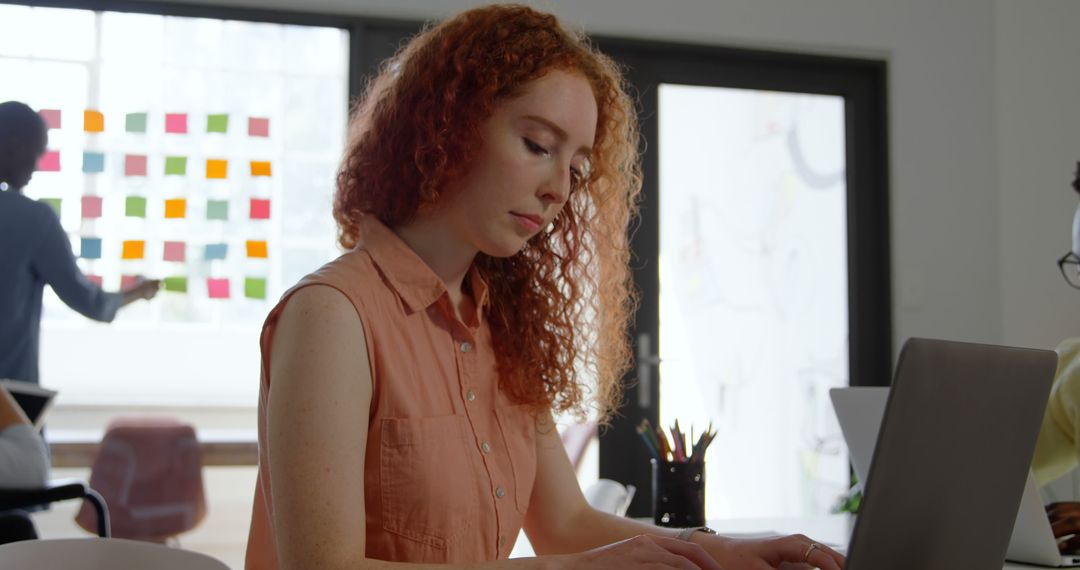 Focused Redhead Businesswoman Working on Laptop in Modern Office - Free Images, Stock Photos and Pictures on Pikwizard.com