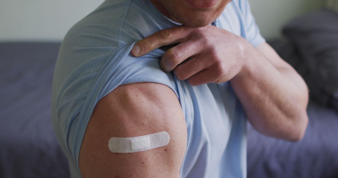 Man Showing Bandage On Arm After Immunization - Free Images, Stock Photos and Pictures on Pikwizard.com