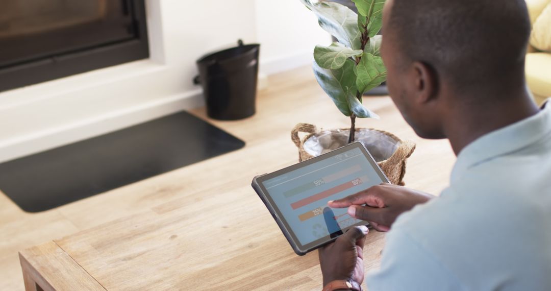 Man Monitoring Home Energy Usage on Tablet in Relaxed Setting