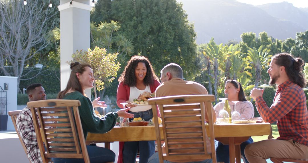 Cheerful Friends Enjoying Meal Outdoors in Sunny Garden - Free Images, Stock Photos and Pictures on Pikwizard.com